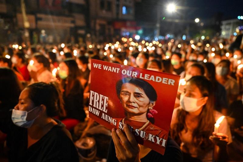 A protester holds a poster with an image of detained civilian leader Aung San Suu Kyi