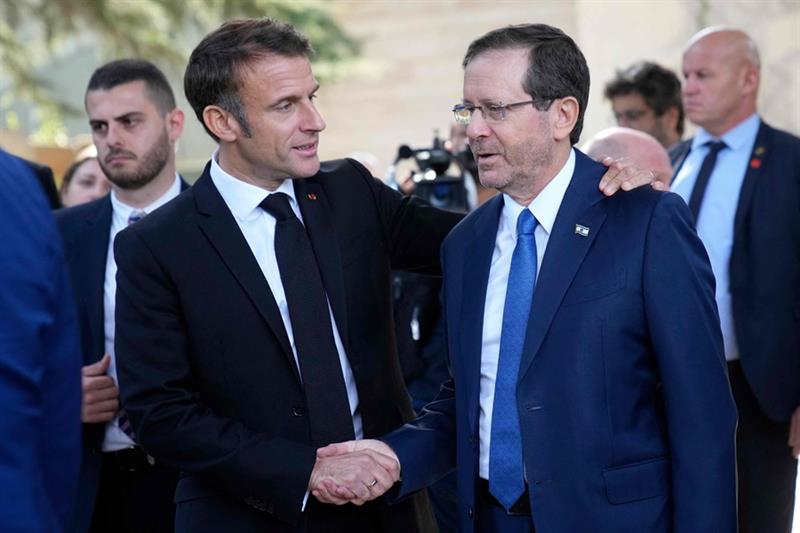 French President Emmanuel Macron (L) shakes hands with Israel s President Isaac Herzog after their t