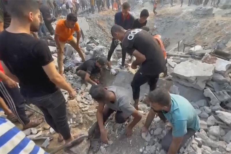 This image grab taken from AFPTV video footage shows Palestinians looking for survivors in a crater