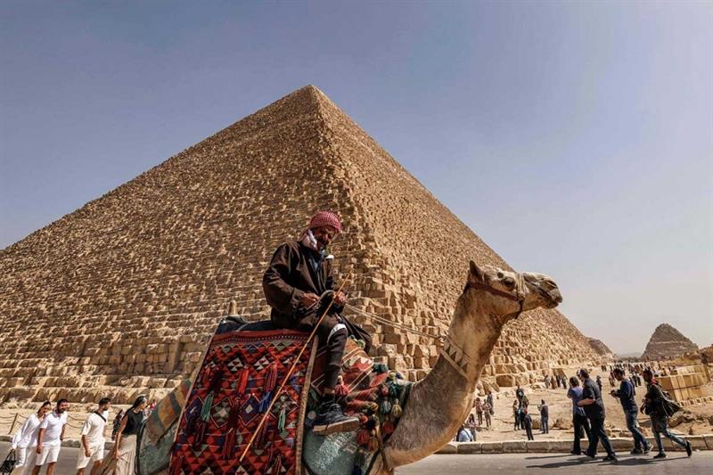 An Egyptian man riding a camel at the Pyramids area.