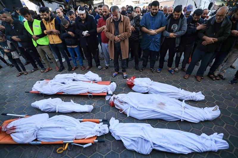 Palestinians mourn over bodies of members of the al-Rifi family who were killed in Israeli bombardme