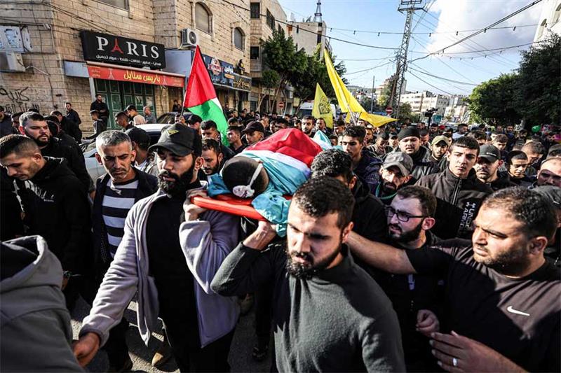 Relatives carry the body of 14-years-old Amr Wahdan, who was killed in clashes with Israeli forces, 