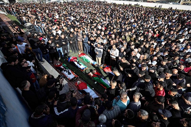  Palestinian mourners carry the bodies of men killed during an Israeli raid in the occupied West Ban