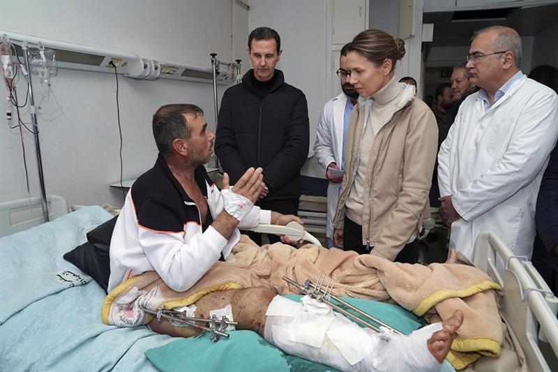 Syrian President Bashar Assad, second left, and his wife Asma, visit a wounded survivor of a devasta