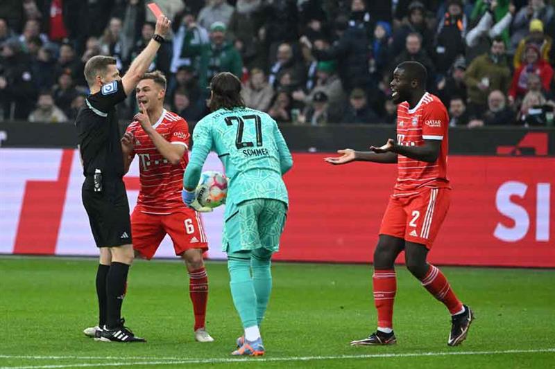 Bayern Munich s French defender Dayot Upamecano (R) is shown a red card by the referee during the Ge
