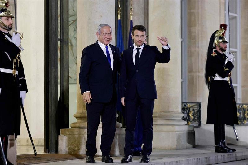 France s President Emmanuel Macron (R) gestures as he welcomes Israel s Prime Minister Benjamin Neta