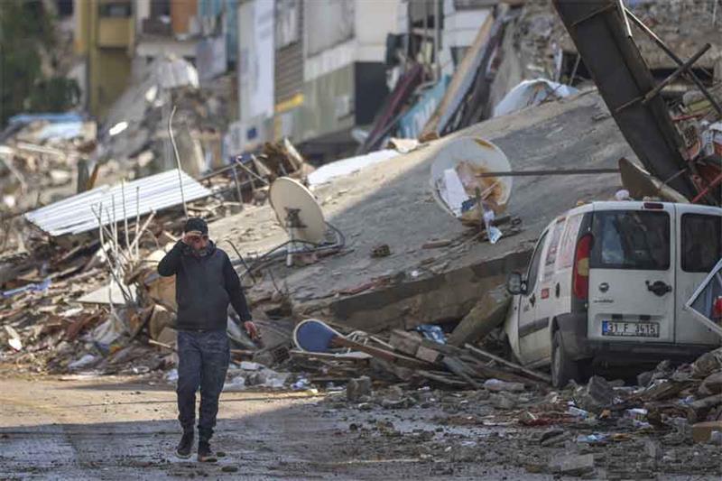 A man walks past debris from destroyed buildings in Antakya, southeastern Turkey, Tuesday, Feb. 21, 