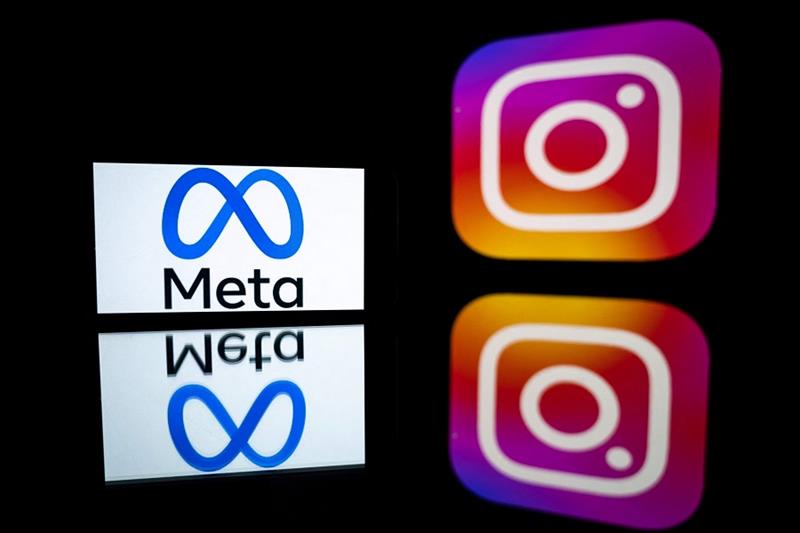 A smartphone and a computer screen displaying the logos of Instagram app and its parent company Meta