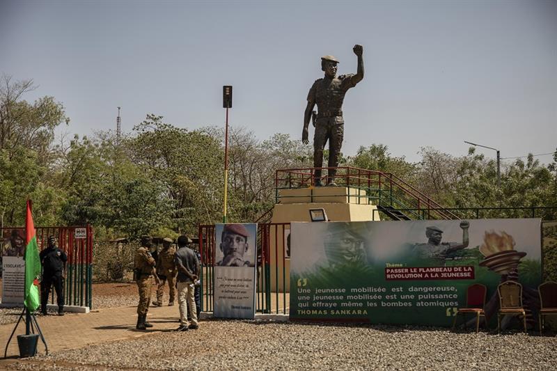 People stand next to a statute of Burkina Faso s revolutionary leader, Thomas Sankara,