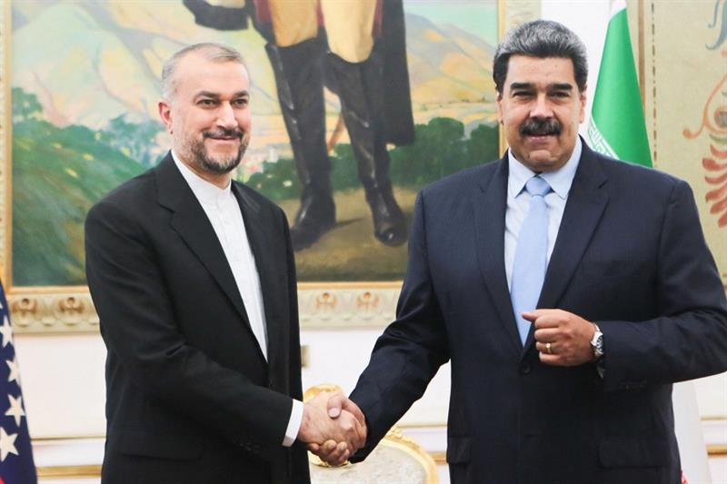 Venezuelan President Nicolas Maduro (R) shaking hands with Iran s Foreign Minister Hossein Amir-Abdo