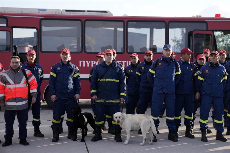 Greek firefighters with dogs wait to board a military plane at Elefsina Air Force Base, Greece 
