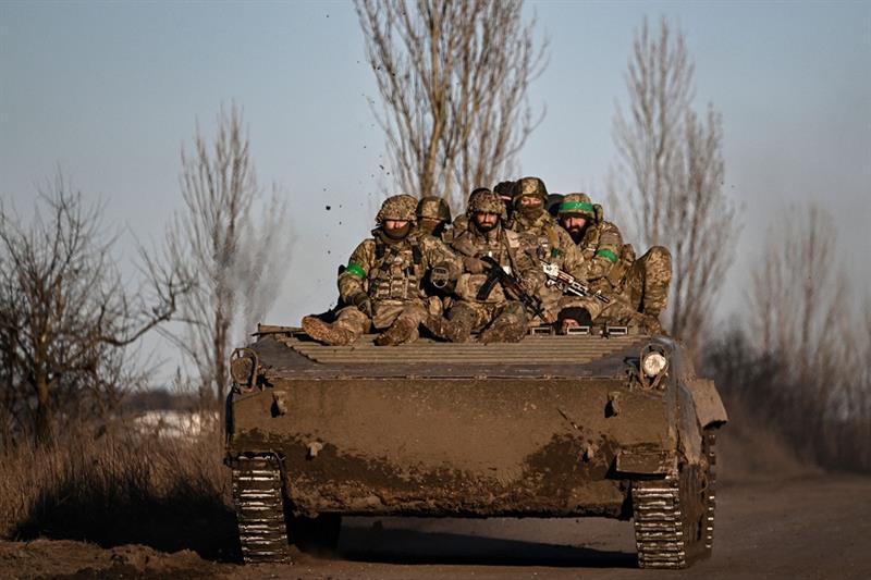 Ukrainian servicemen sit on a BMP military vehicle as they move towards Bakhmut