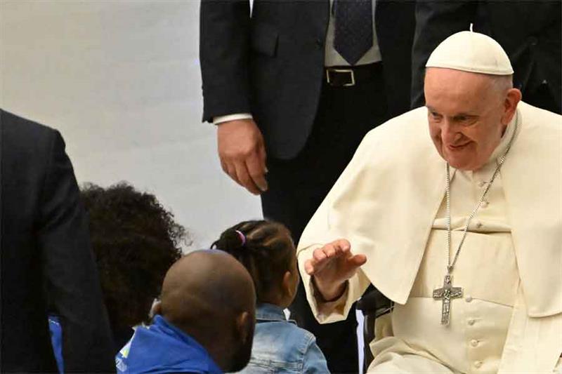 Pope Francis blesses children as he holds an audience to refugees who arrived under humanitarian cor