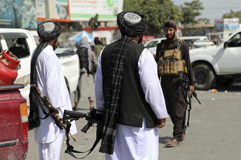 Taliban fighters stand guard in front of the Hamid Karzai International Airport, in Kabul