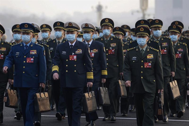 Military delegates wearing face masks arrive to attend the opening session of China s National Peopl