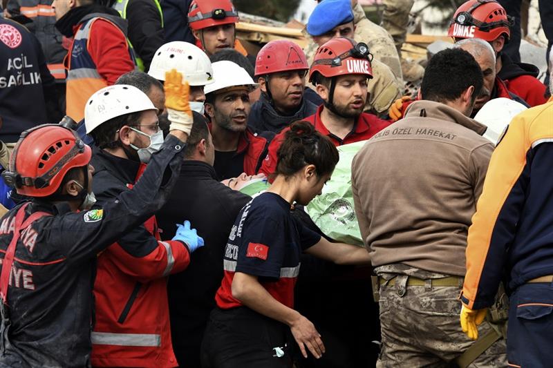 Rescue workers carry a girl pulled out from a collapsed building to an ambulance, in Malatya, Turkey