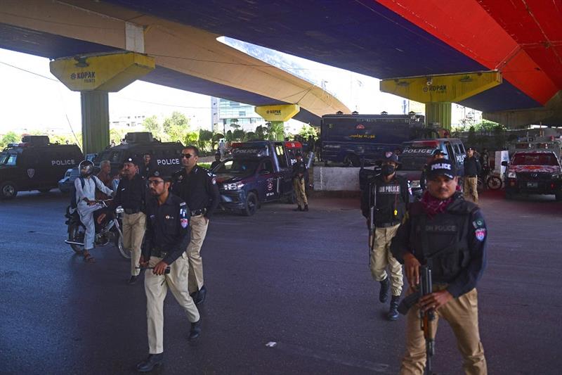 Policemen stand guard along a roadside in Karachi on May 10, 2023.