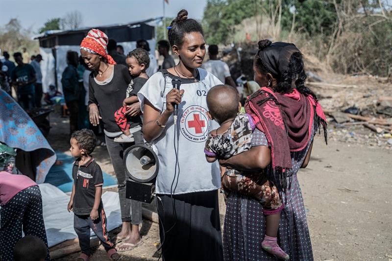 A Red Cross volunteer helps refugees from Sudan who crossed into Ethiopia in Metema, on May 5, 2023.