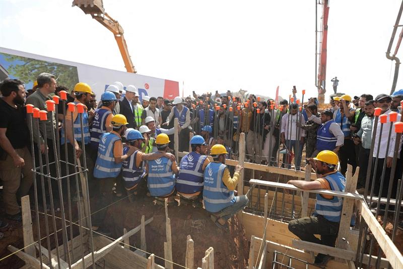 Construction workers attend the inauguration of a Turkish-funded housing complex for the internally 