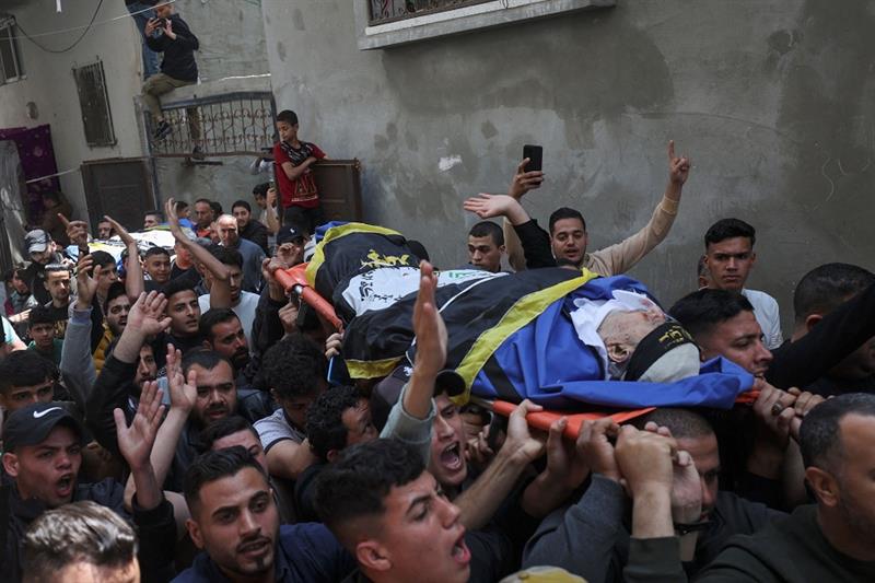Mourners carry the bodies of Palestinian Islamic Jihad group member Jihad Ghannam and his wife 