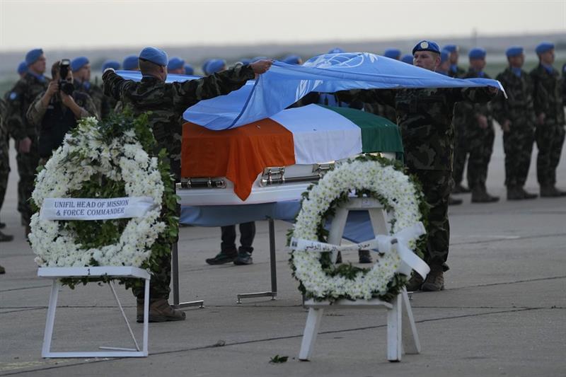 Irish U.N. peacekeepers remove the United Nations flag from the coffin of their comrade Pvt. Sean Ro