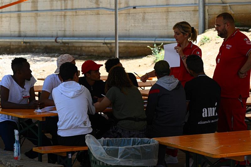 Red Cross volunteers with young Migrants.