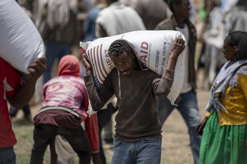 An Ethiopian man carries a sack of wheat on his shoulders to be distributed by the Relief Society of