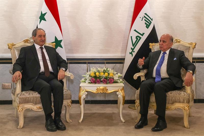 Iraqi Foreign Minister Fuad Hussein (R) receives his Syrian counterpart Faisal Mekdad in Baghdad on 