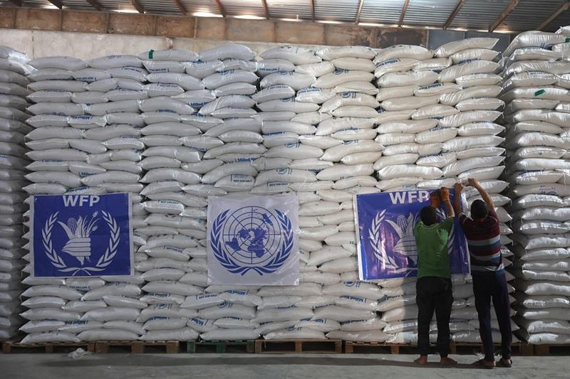 Workers unload bags of aid at a warehouse near the Syrian Bab al-Hawa border crossing with Turkey