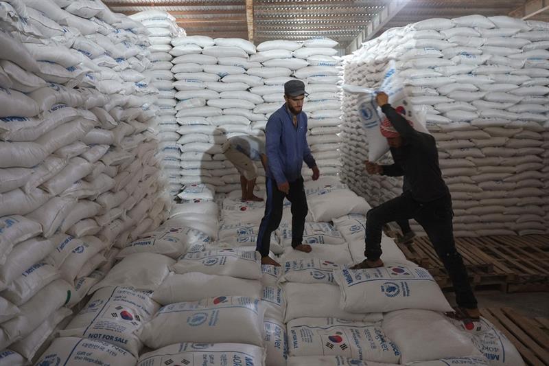 Workers unload bags of aid at a warehouse near the Syrian Bab al-Hawa border crossing with Turkey, o