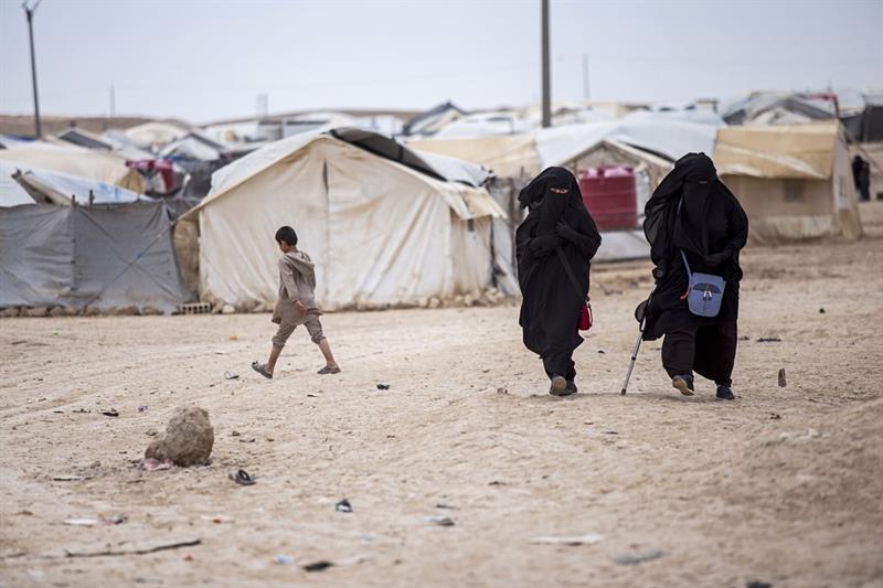 Women walk in the al-Hol camp that houses some 60,000 refugees, including families and supporters of