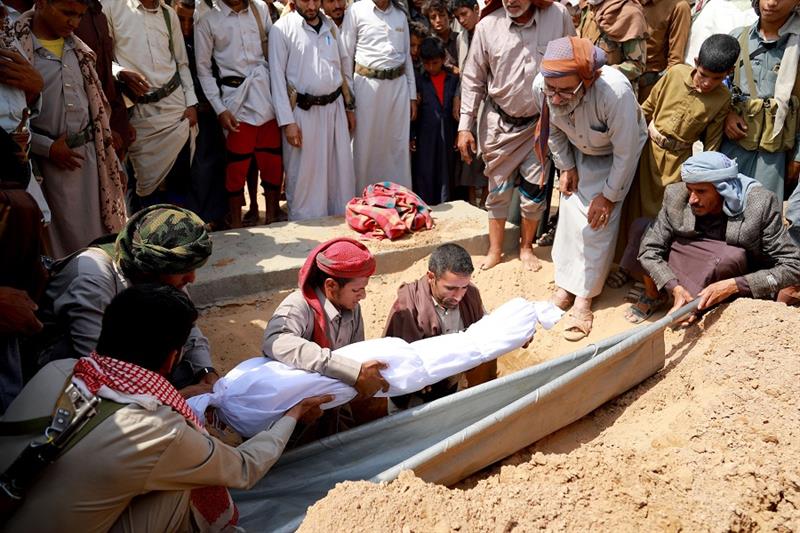 Mourners bury one of three children, killed in a landmine, during their funeral in Marib