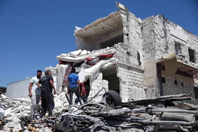 People inspect the rubble of a house following reported Russian airstrikes on the western outskirts 