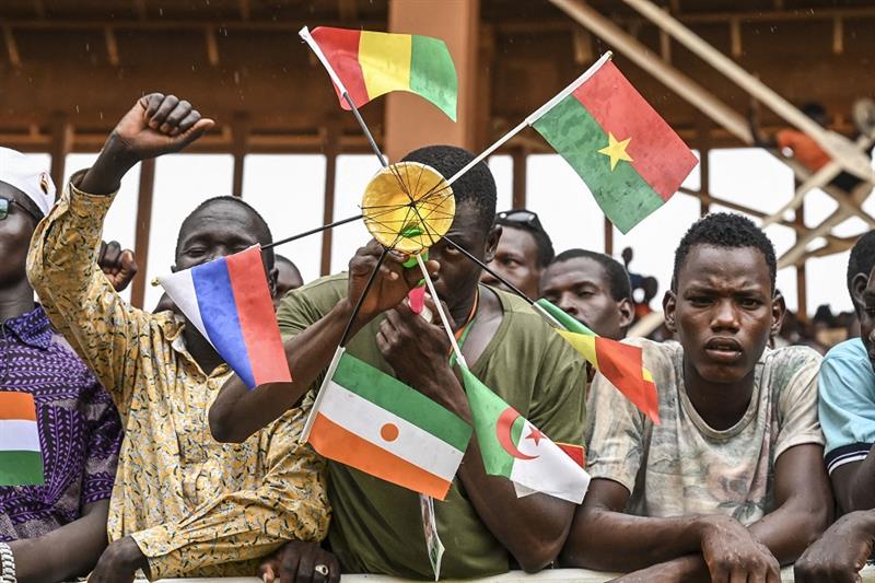 A supporter of Niger s National Council for Safeguard of the Homeland (CNSP) holds national flags of