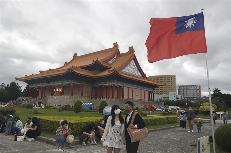 People wearing face masks walk around the Chiang Kai-shek Memorial Hall in Taipei, Taiwan, on Oct. 9