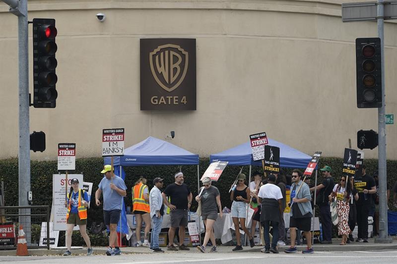 Picketers walk outside the gates of Warner Bros., studios in Burbank, Calif., Thursday, Sep. 21, 202