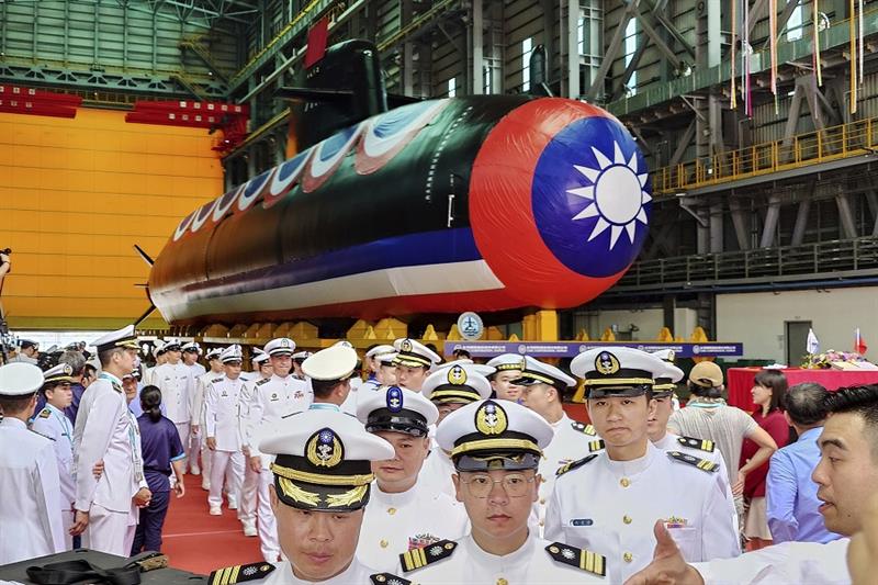 A group of navy personnel pass through Taiwan s domestically-made submarine during the naming and la
