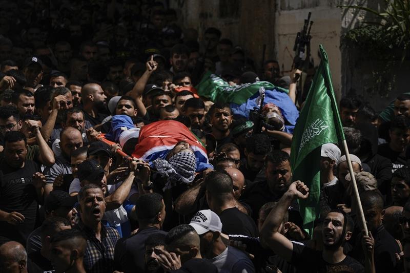 Mourners carry the bodies of Asid Abu Ali, 21, and Abdulrahman Abu Daghash, 32, draped in the Hamas 