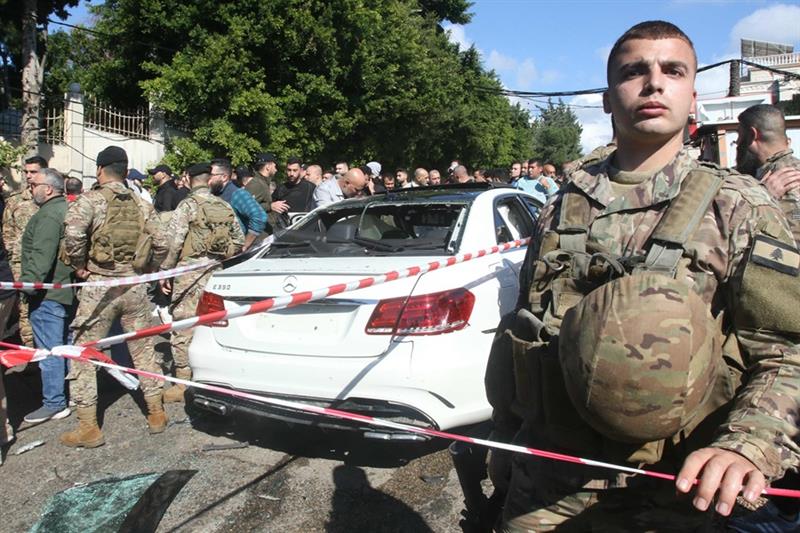 Lebanese army soldiers secure the area around a car wrecked in a reported Israeli drone strike in th