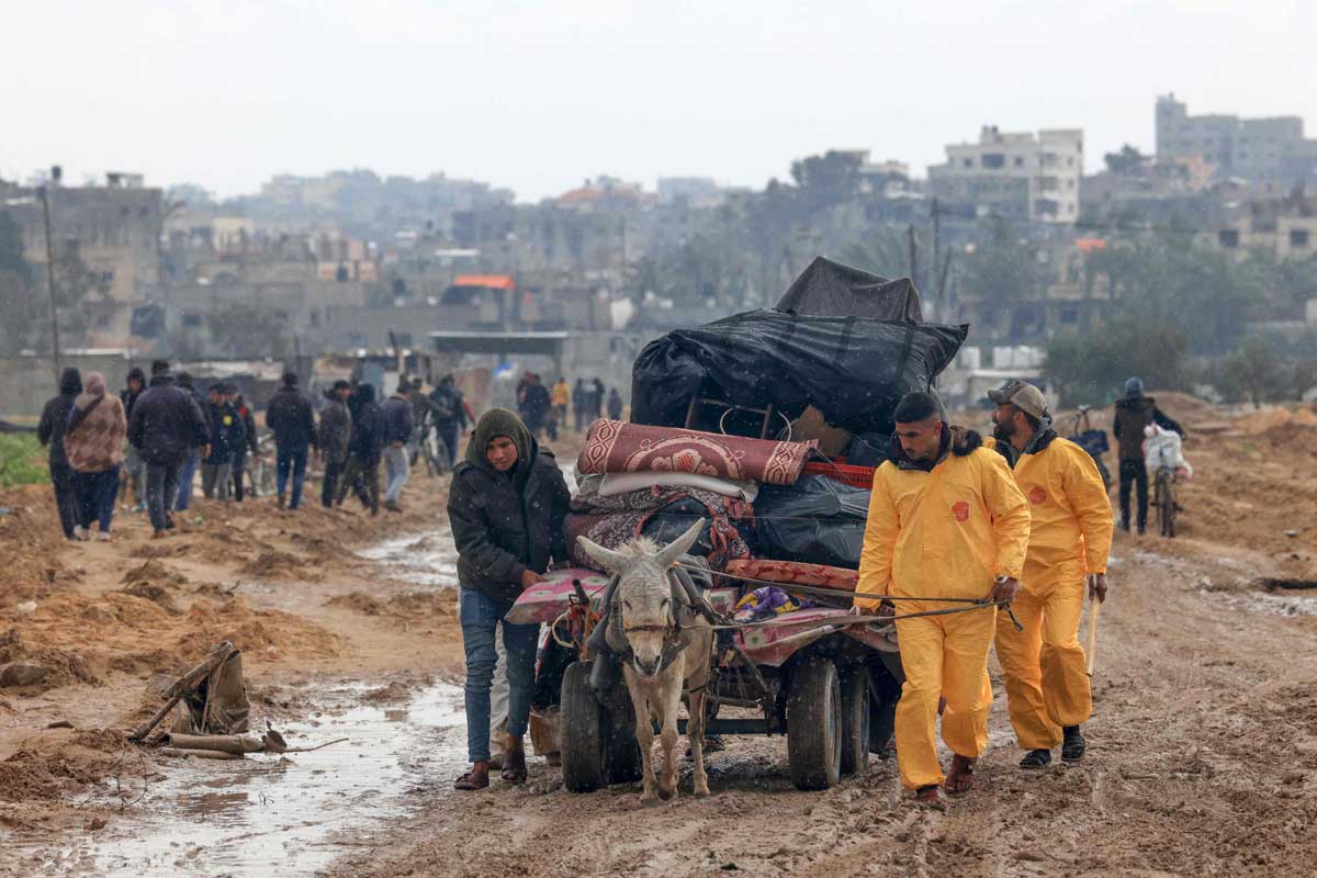 PHOTO GALLERY: Palestinians 'hazmat' their way through war and rain in Gaza