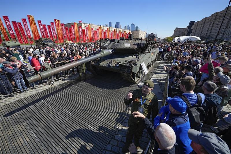 Visitors look at and take photos of a German made Leopard 2A6 tank, hit and captured by Russian troo